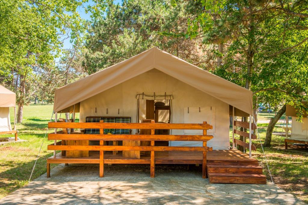萨武德里亚SunFlower Camping Savudrija的田野上带长凳的小帐篷
