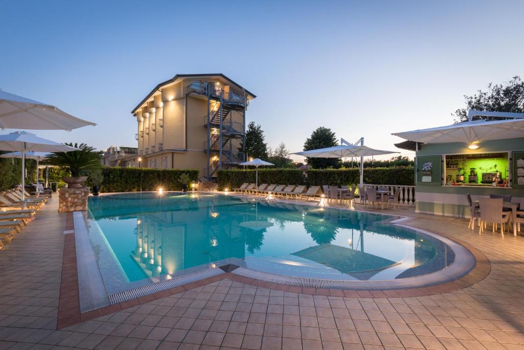 马里纳迪马萨蒂兹雅娜酒店的一座带椅子的大型游泳池和一座建筑