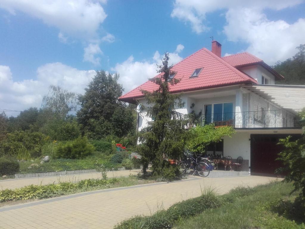 DwikozyDom w Zielonej Dolinie的路边有红色屋顶的白色房子