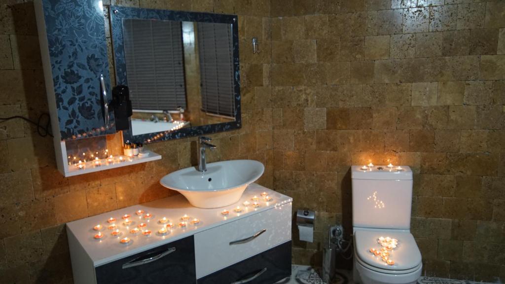 GeredeliCastle Nolana的浴室设有水槽和带圣诞灯的卫生间。