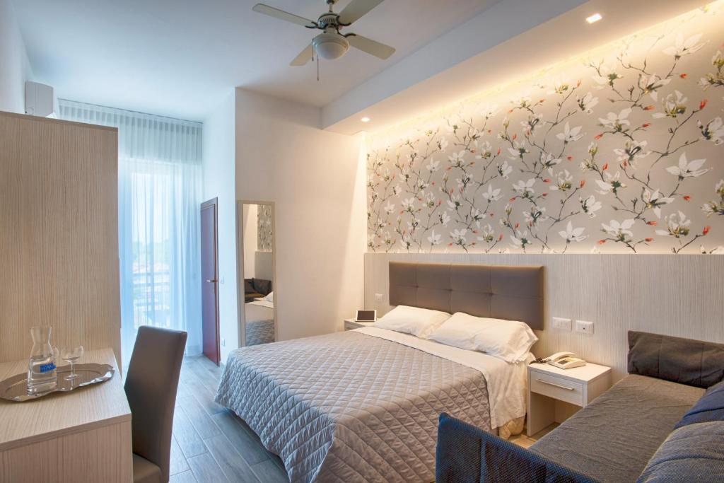 里米尼Hotel Mirabel的一间卧室设有一张床和鲜花墙