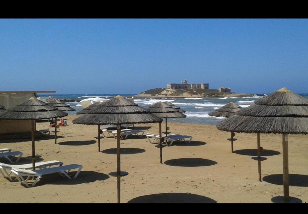波托帕洛Casa del sole的海滩上的一组椅子和遮阳伞