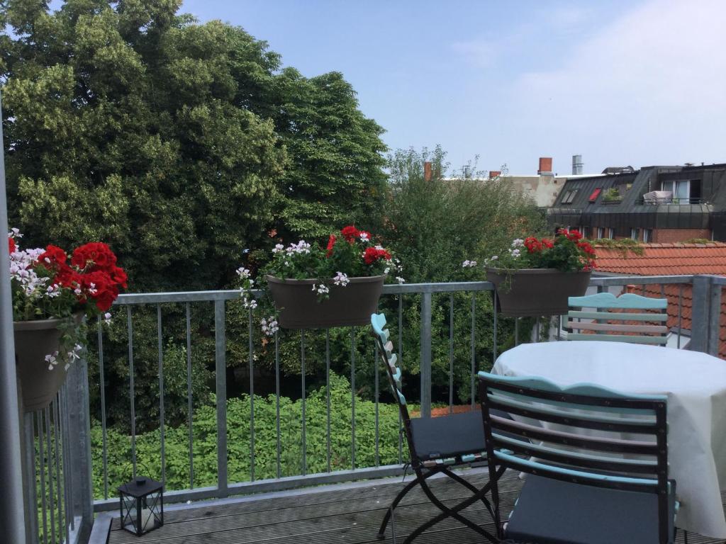 吕贝克Grö 13的阳台设有桌子,在围栏上种着鲜花
