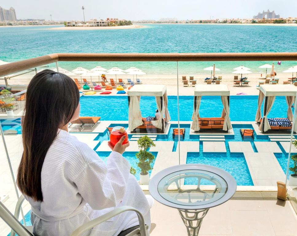 迪拜Royal Central Hotel and Resort The Palm的坐在一艘载有苹果的游轮上的女人