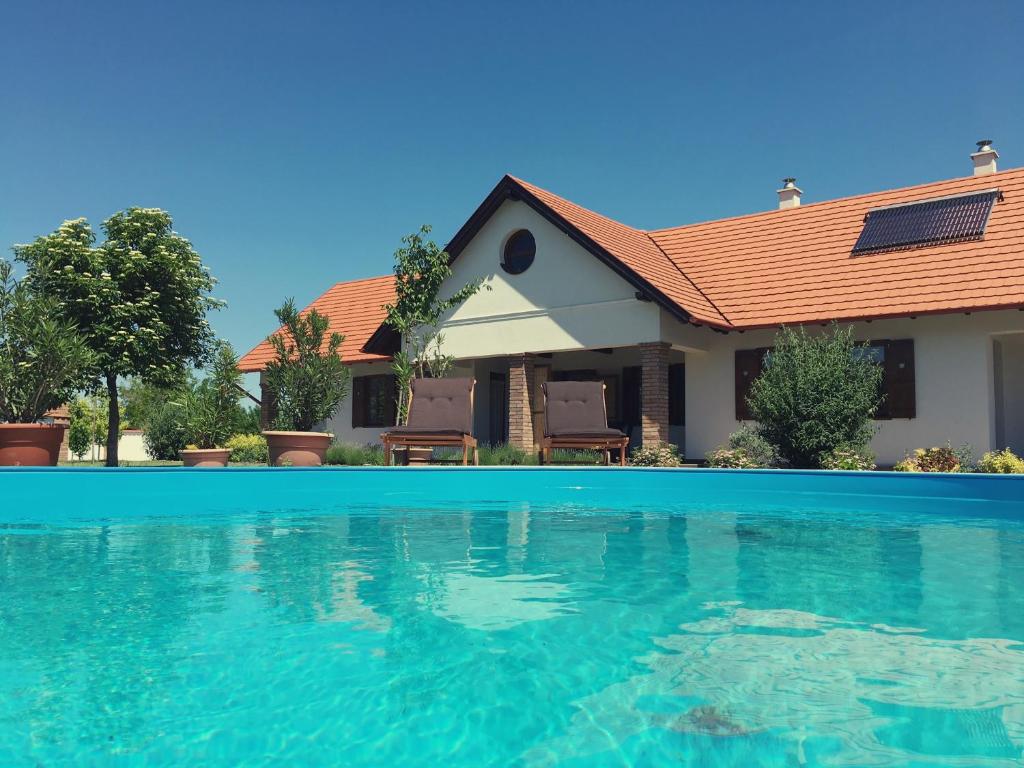 波罗斯洛Kamillaház的一座房子前面设有游泳池