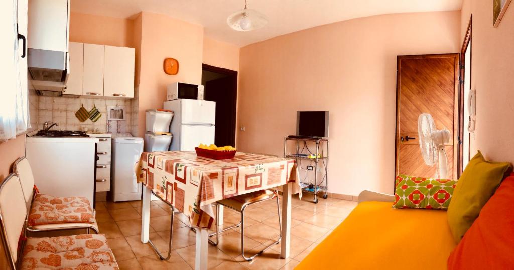 西尼斯科拉appartamento vacanze Sardegna的一间带桌子的厨房和一间带冰箱的厨房
