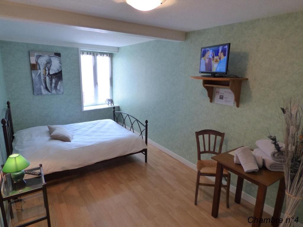 Saint-Igny-de-VersAuberge Des Petits的一间卧室配有一张床、一张桌子和一张书桌
