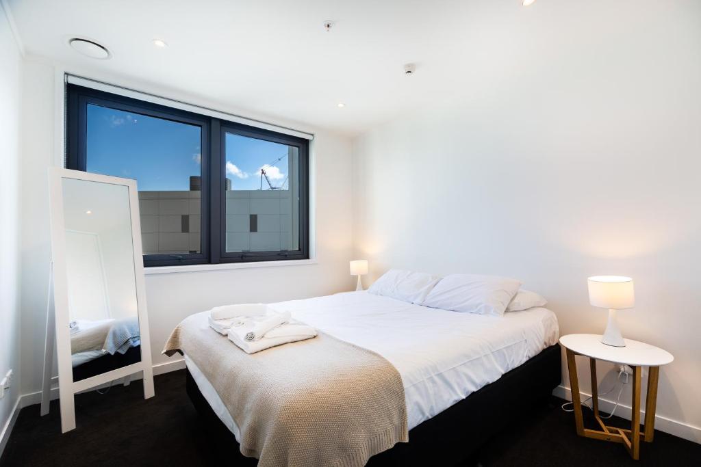 奥克兰Brand New Auckland Apartment的白色的卧室设有床和窗户