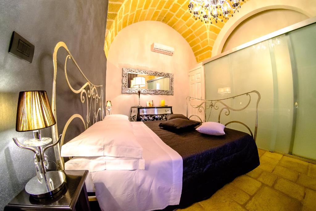 阿莱齐奥Palazzo Aurora的一间卧室配有一张床和一个吊灯