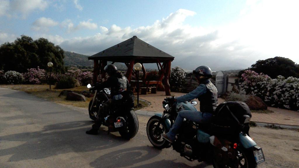 TulaAgriturismo Pedru Caddu的两人骑摩托车在带凉亭的道路上