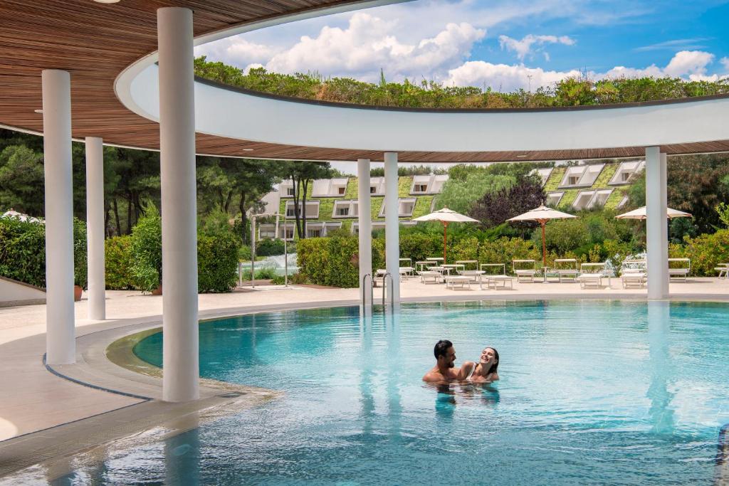 卡斯特拉巴特滨海Ethra Reserve Kalidria的两人在酒店的游泳池里