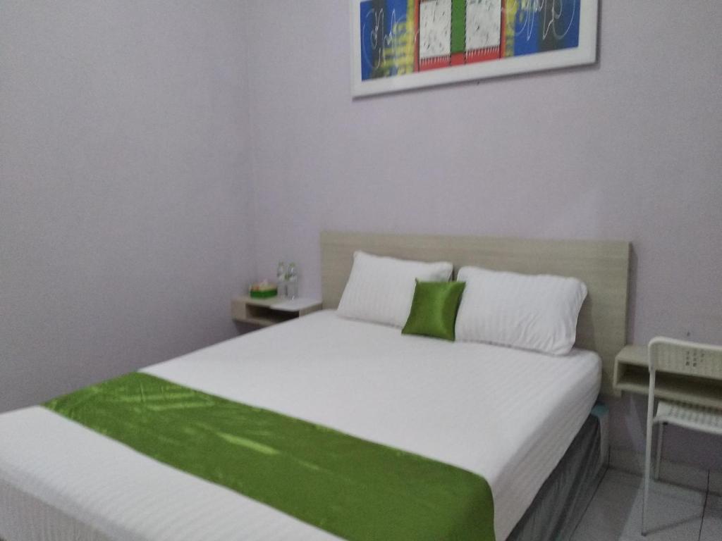 Cibuburde' GREEN Cibubur的卧室配有带绿色床单的大型白色床