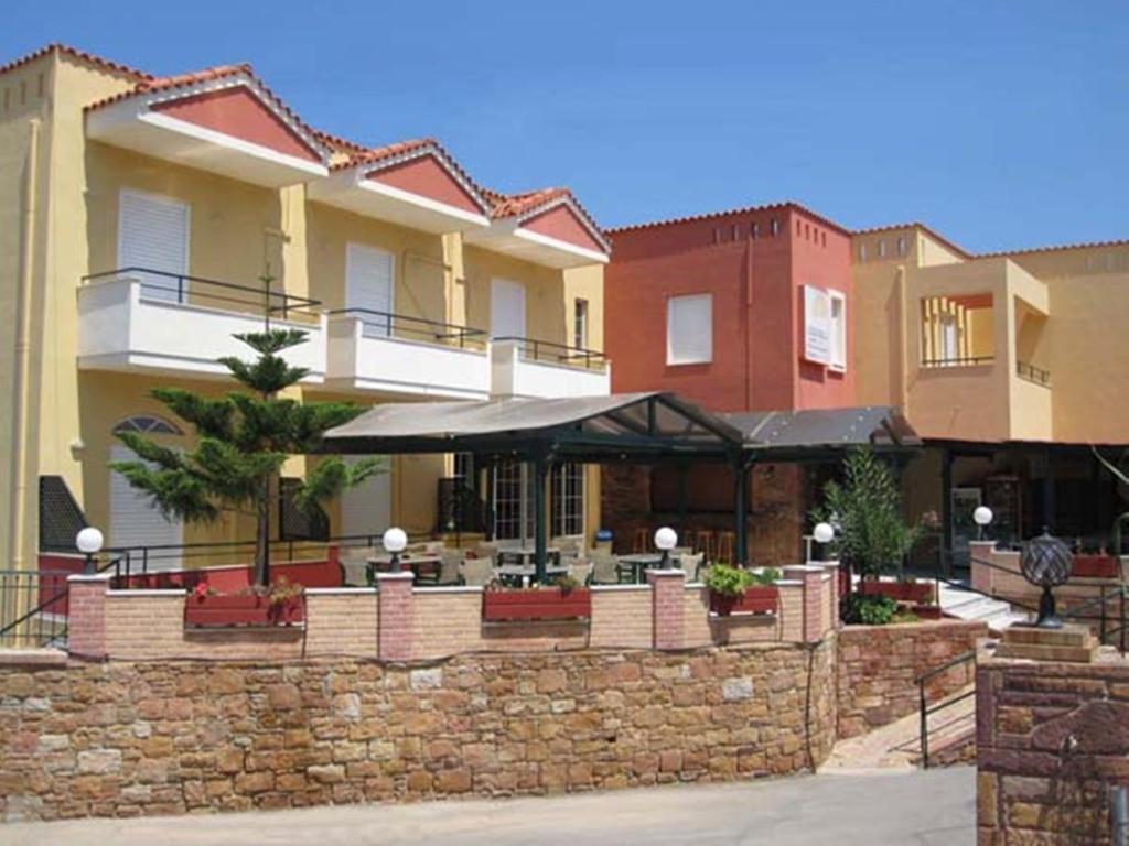 Agia ErmioniSunrise Hotel的一座带石墙的建筑,设有户外庭院