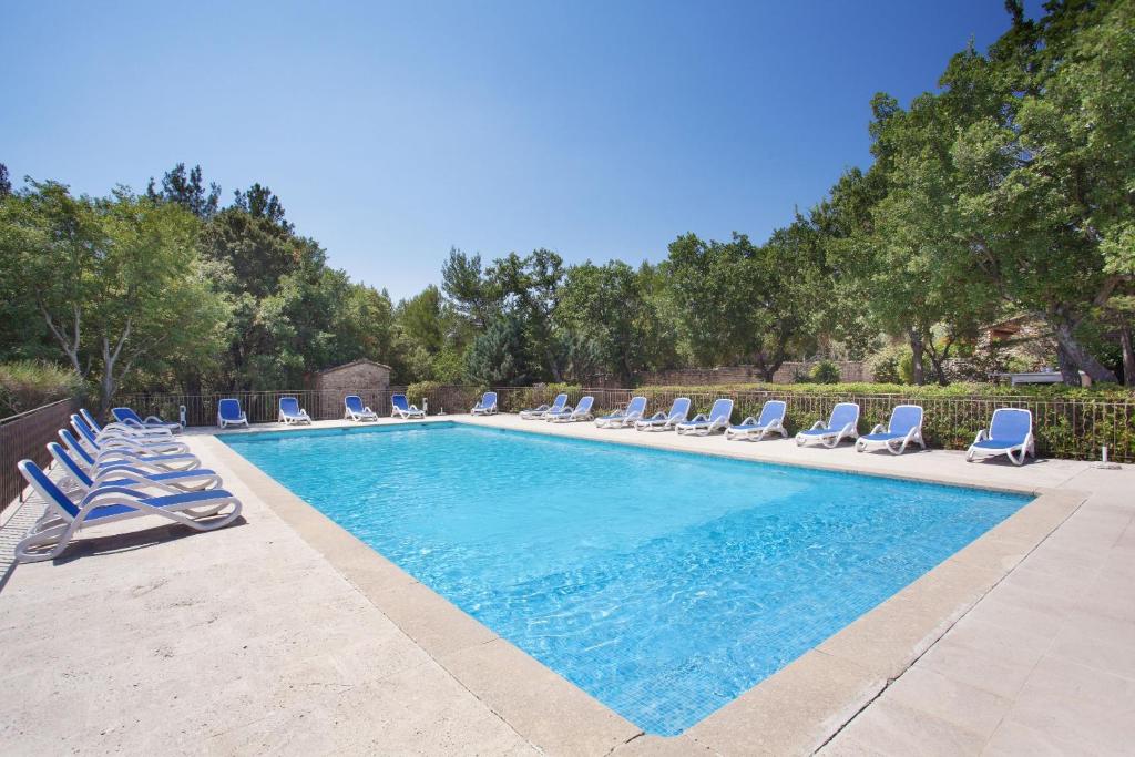 戈尔德Résidence Prestige Odalys La Bastide des Chênes的一个带躺椅的游泳池和一个游泳池