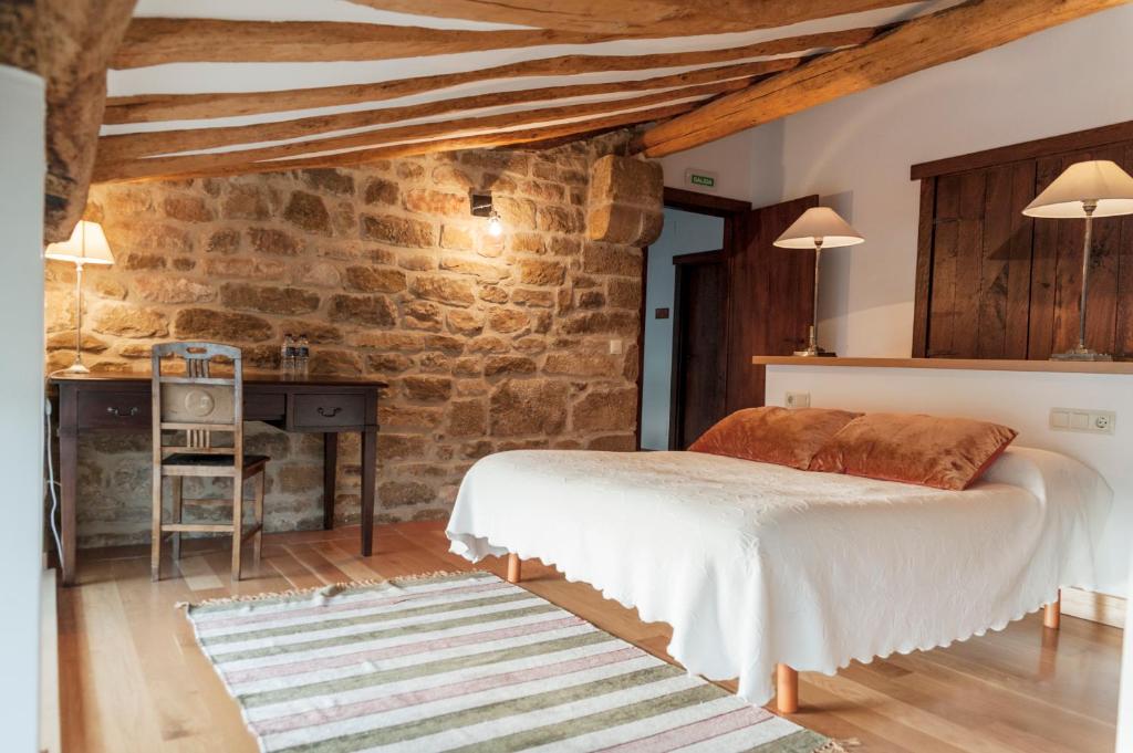 MurugarrenCasa Baquedano的一间卧室设有一张床和石墙