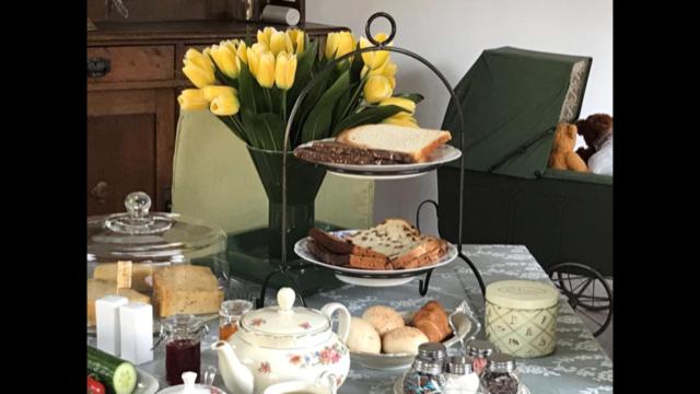 巴伦德雷赫特Bed and breakfast devijfbees的一张桌子,上面有两盘食物和一个花瓶