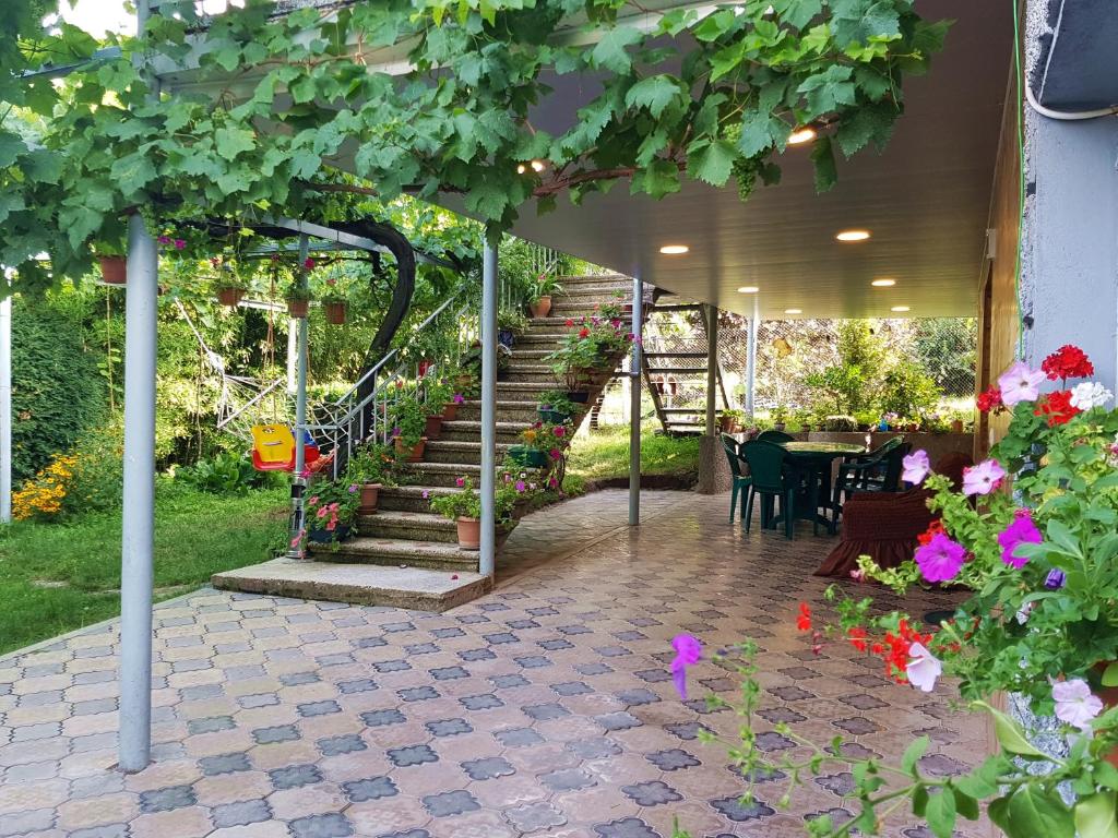 泰拉维Valiko house in Telavi的庭院设有楼梯、桌子和鲜花