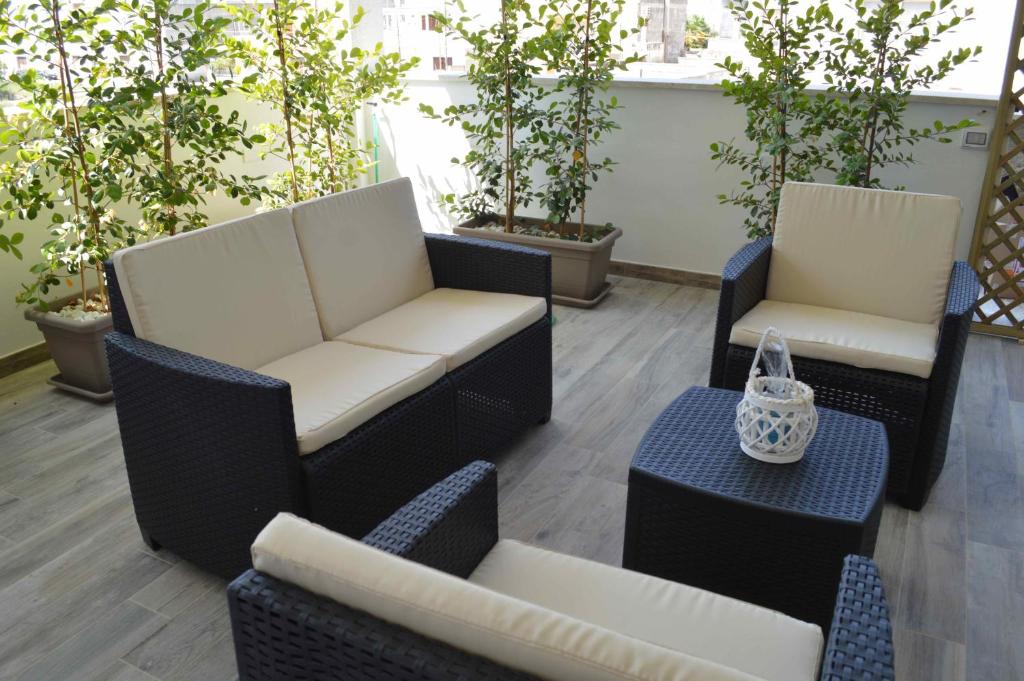 莱韦拉诺Casa Vacanze Infiore的庭院设有两把椅子和桌子,种有植物