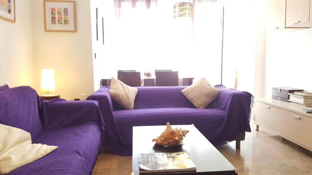 休达Gran Vía flat的客厅配有紫色沙发和桌子