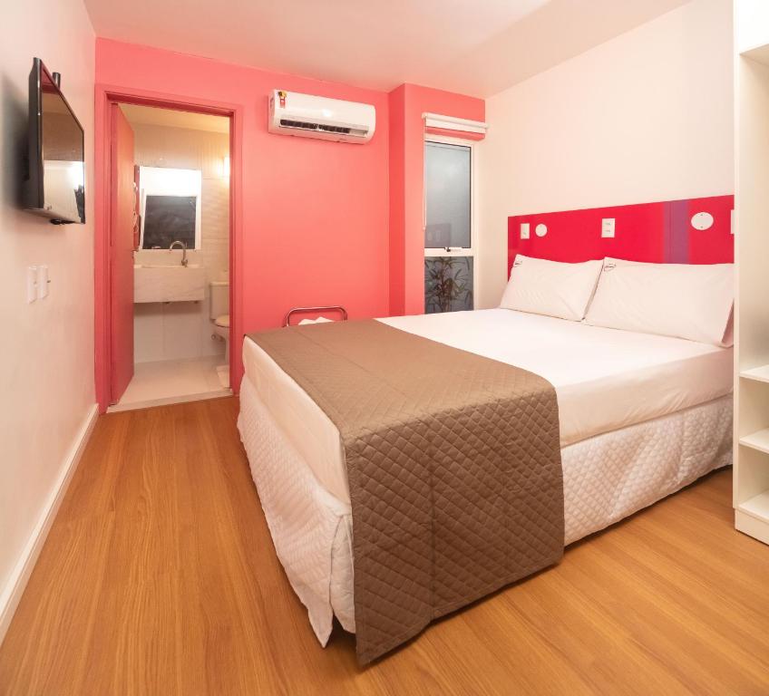 马塞约Zuza Slim Suítes的酒店客房设有一张大床和一间浴室。
