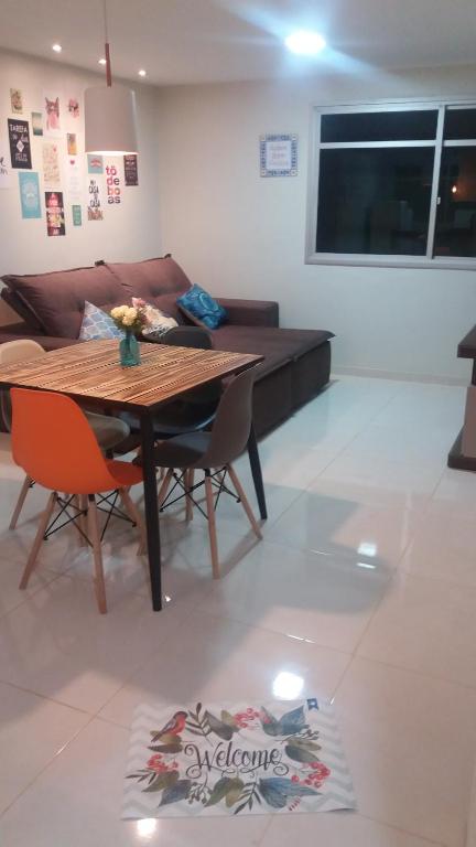 瓜拉派瑞Apartamento Ed. Ouro Preto Praia do Morro的客厅配有木桌和椅子