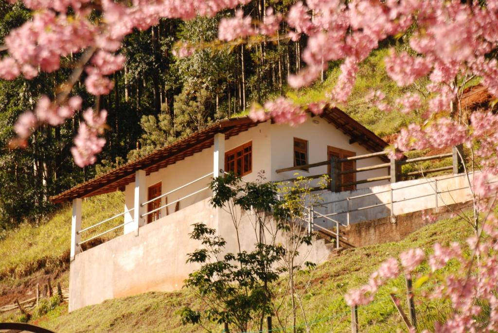 圣弗朗西斯科泽维尔Chalés de Valfena的山丘上一座粉红色花房