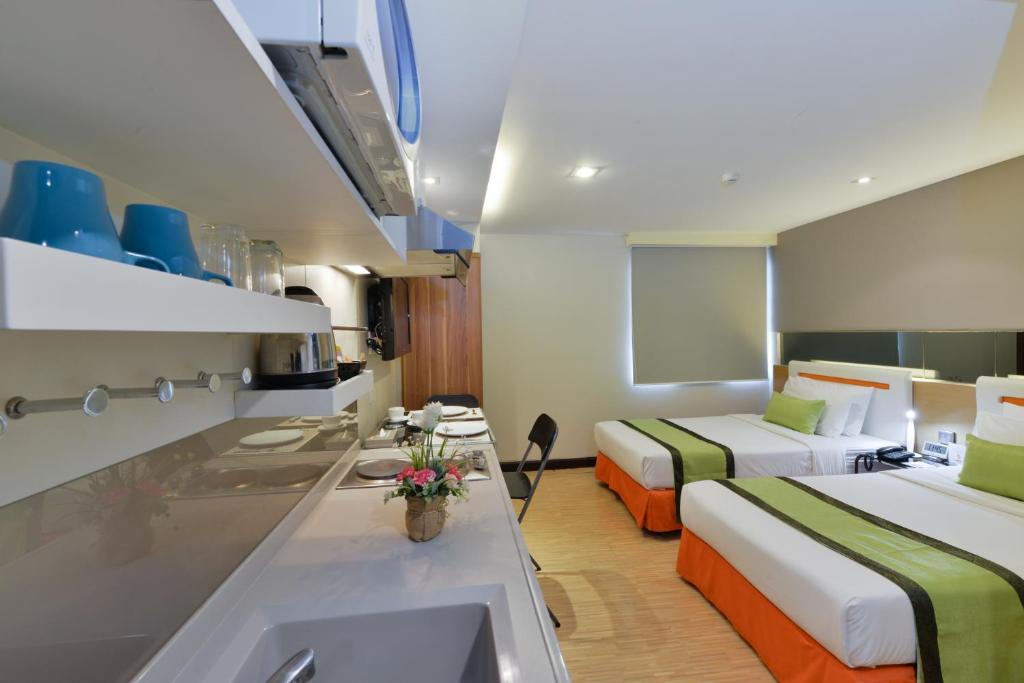 曼谷Arawana Express Phromphong的酒店客房设有两张床和盥洗盆