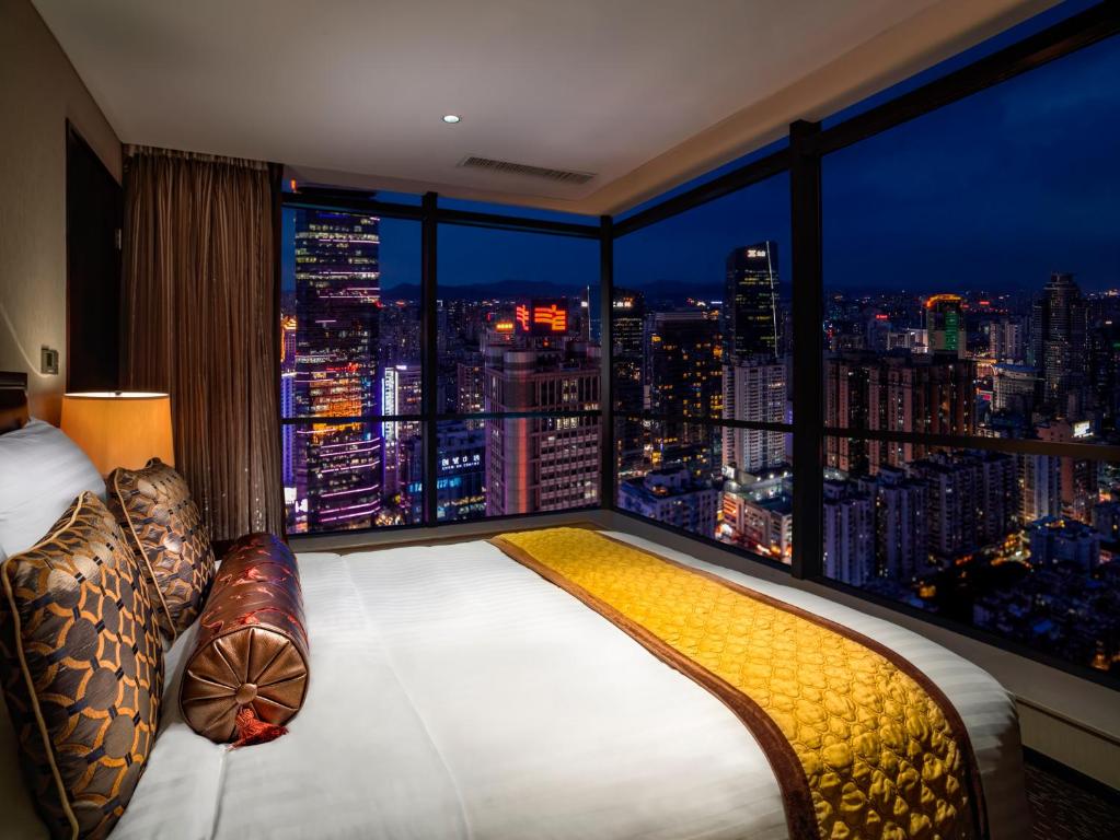 广州广州方圆奥克伍德豪景酒店公寓的一间卧室设有大窗户,享有城市天际线