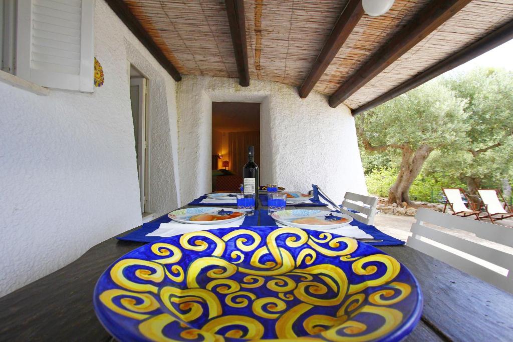 莱乌卡Trulli Leuca的一张桌子,上面有蓝色和黄色的桌布