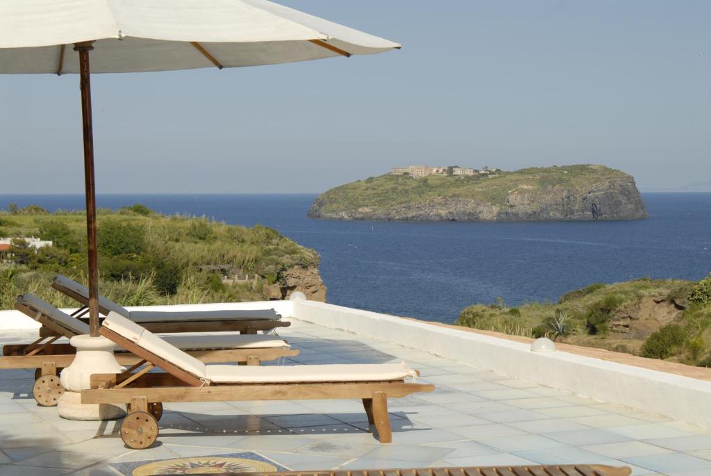 文托泰内Hotel Agave e Ginestra的一排带遮阳伞的躺椅和大海