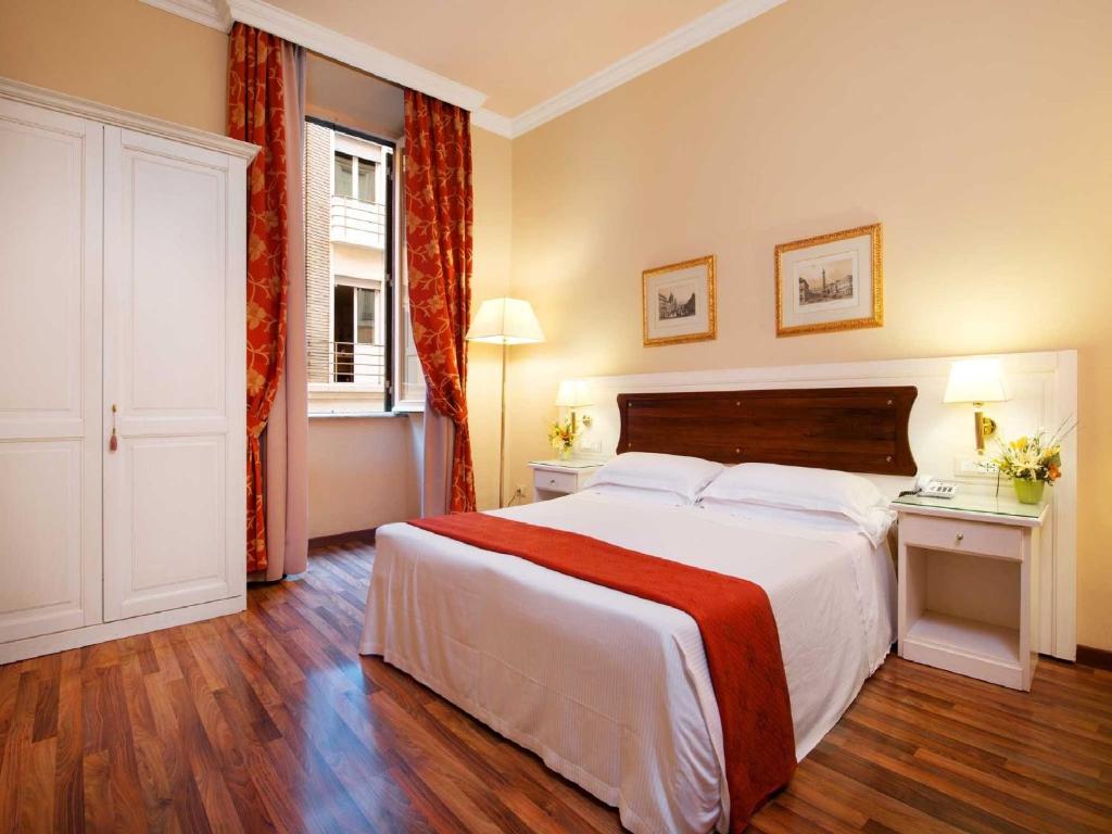罗马多米兹伊诺奥酒店的卧室设有一张白色大床和一扇窗户。