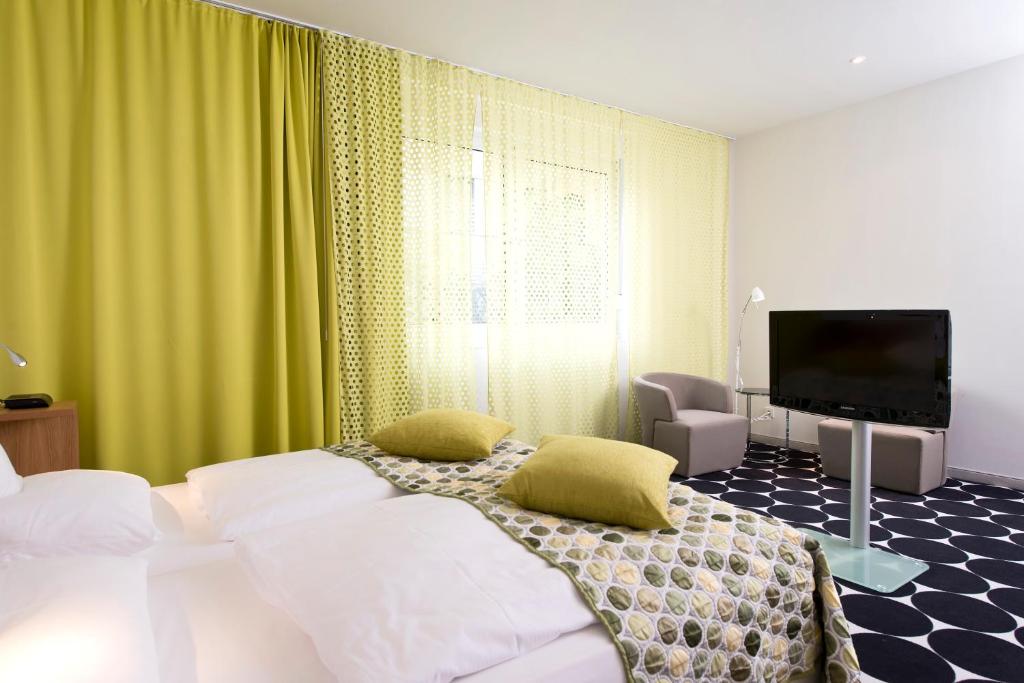 美因河畔法兰克福法兰克福温德姆特里普酒店的一间卧室配有一张床和一台平面电视
