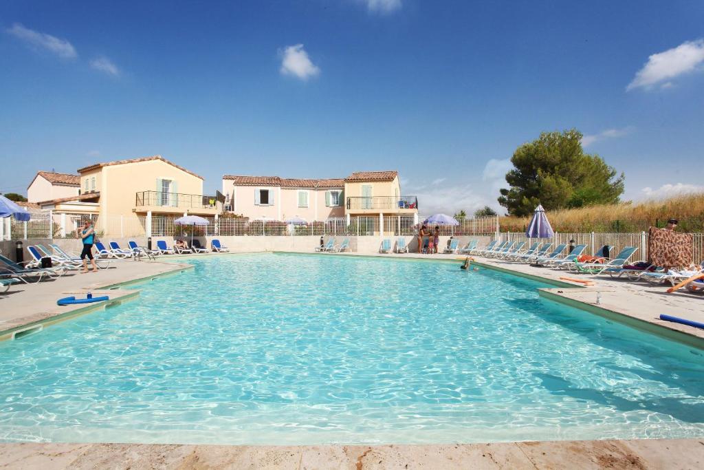 卡布列斯Terres de France - Résidence de la Cabre d'Or的度假村内带躺椅的大型游泳池