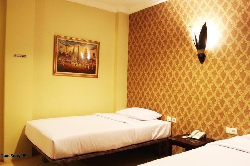 雅加达Twins Hotel的卧室配有两张床,墙上挂着一幅画