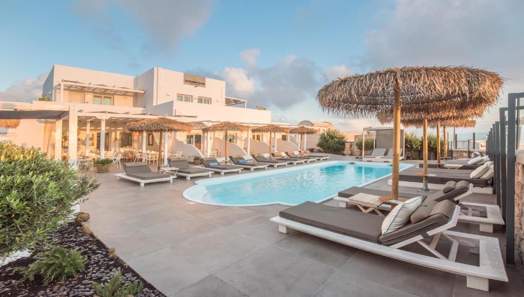 皮尔戈斯伊姆普莱希芙万酒店的一个带躺椅和遮阳伞的游泳池