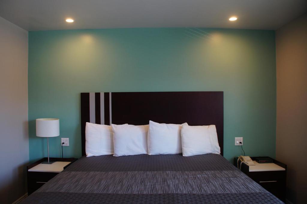 长滩海滩旅馆汽车旅馆的卧室配有带白色枕头的大床