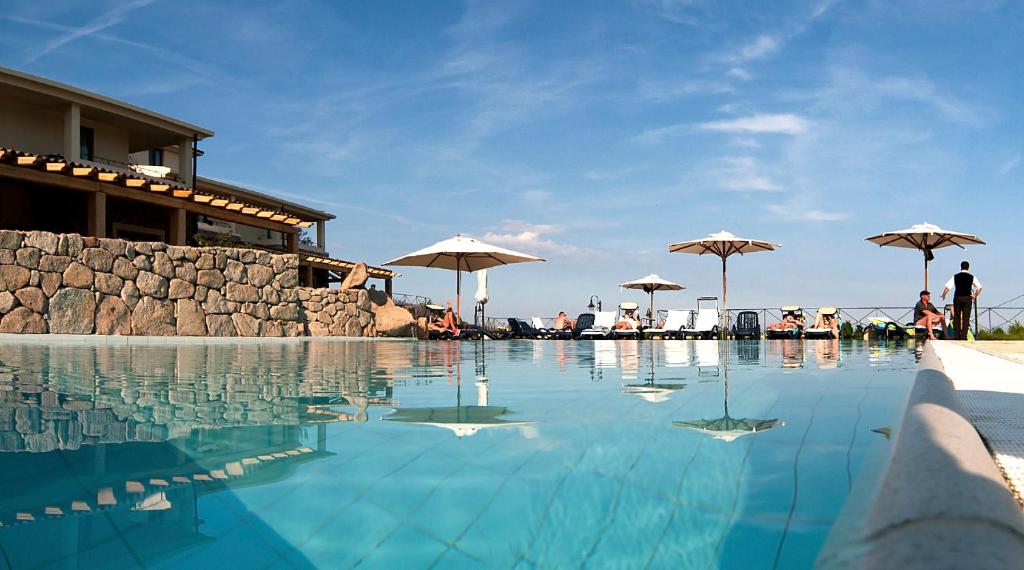 卡拉古诺内古斯图伊马里斯别墅酒店的游泳池配有遮阳伞,周围的人可以围着游泳池