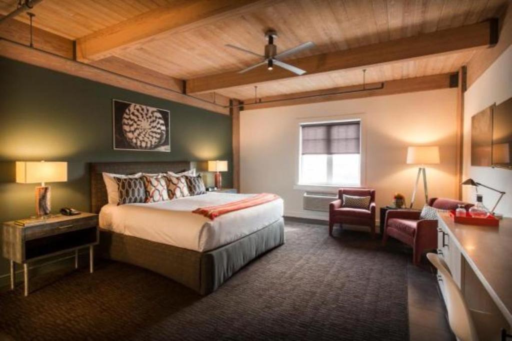 加尔维斯敦海港码头之家酒店的卧室配有床、椅子和窗户。