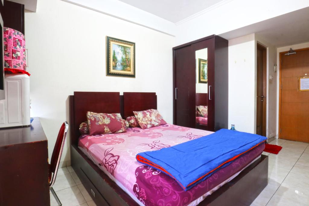 德波Dewi Depok Apartment Margonda Residence 2的一间卧室配有一张带粉红色和蓝色床单的床