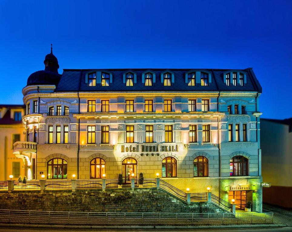 日利纳Boutique Hotel Dubná Skala的一座在晚上有灯的大建筑
