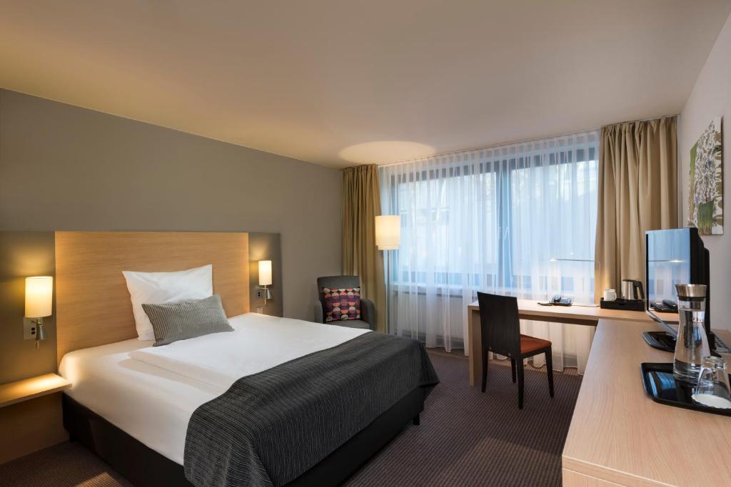 诺伊斯杜塞尔多夫诺伊斯美居酒店的配有一张床和一张书桌的酒店客房