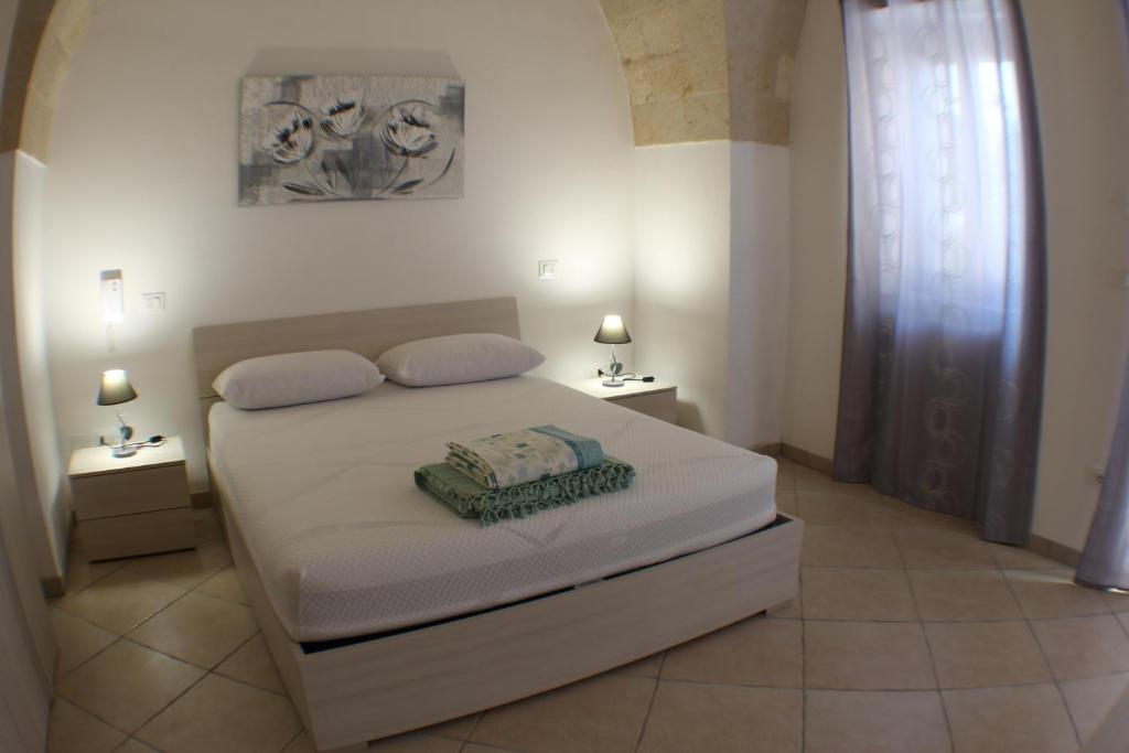 穆罗莱切塞Locazioni turistiche POZZODONTE e MESSAPIA的一间卧室配有白色床和2个床头柜