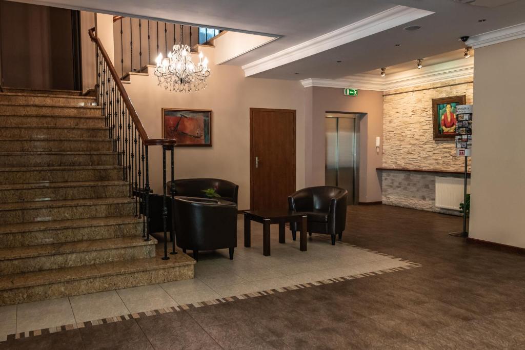普瓦维普利马公寓式酒店的大堂设有楼梯、椅子和吊灯。