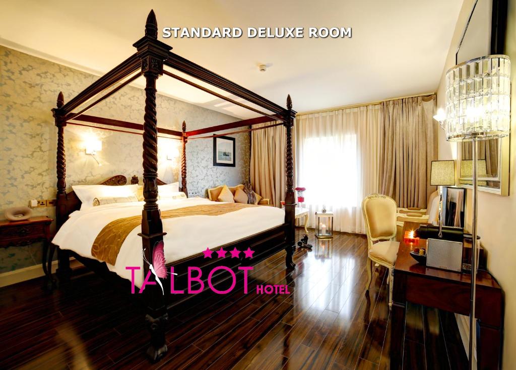 贝尔马利特塔尔波特酒店的一间卧室配有一张天蓬床和一张书桌