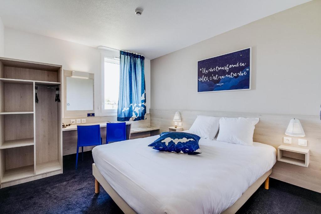 圣萨蒂南Ace Hôtel Le Mans的卧室配有白色大床和蓝色椅子