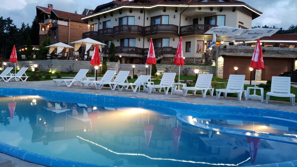 西格伏沙尔克埃泰尔诺家庭酒店的酒店前方的游泳池配有椅子和遮阳伞