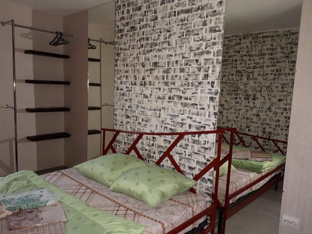 KanskАпартаменты двухкомнатные的卧室设有砖墙和一张双层床。