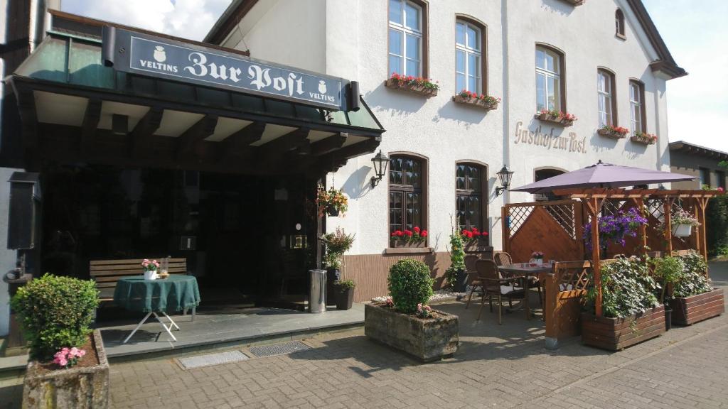 CobbenrodeGasthof zur Post的大楼前带桌子的餐厅