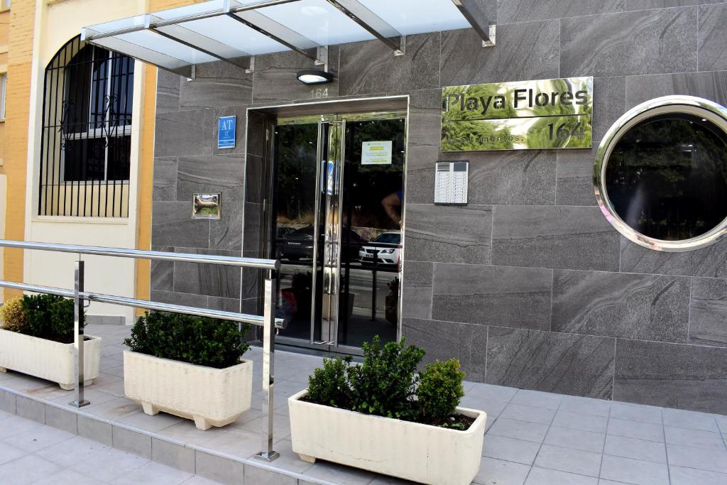 多列毛利诺斯Club Playa Flores的门前有两株盆栽植物的建筑物