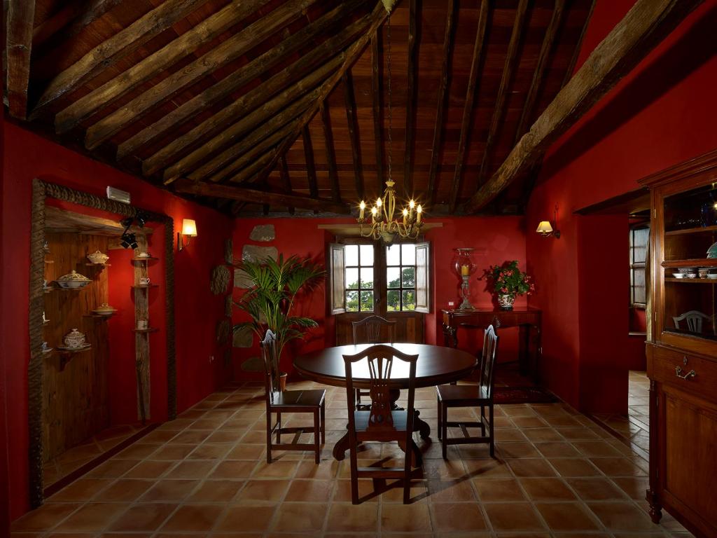 Valle de Guerra海赛达德瓦丽螺斯肯雅乡村民宿的一间拥有红色墙壁和桌椅的用餐室